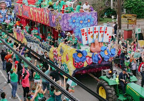 A lively parade with a colorful float, people waving, and a joyful crowd on