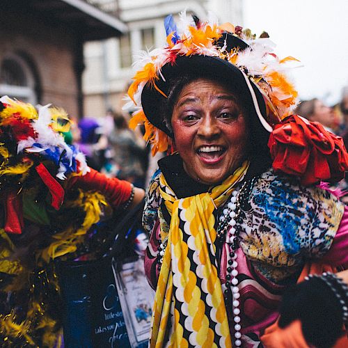 A joyful person in vibrant, festive attire is likely enjoying a carnival or parade.